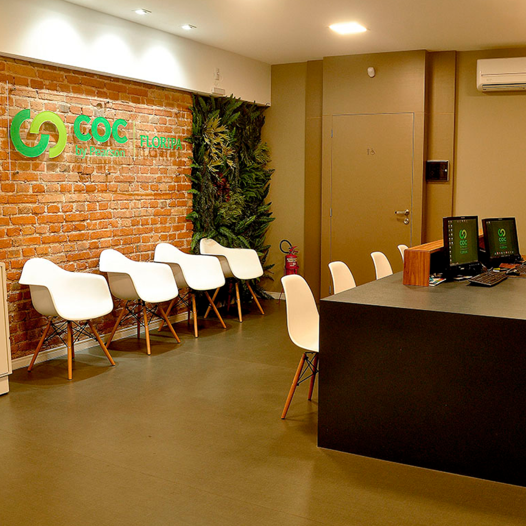 Uma sala de espera com cadeiras brancas.